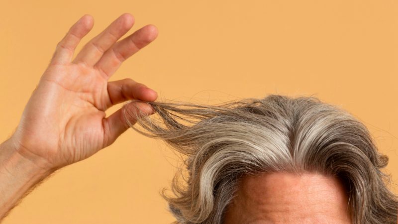 elder man holding his gray hair